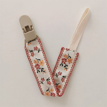 attache tetine orange marron